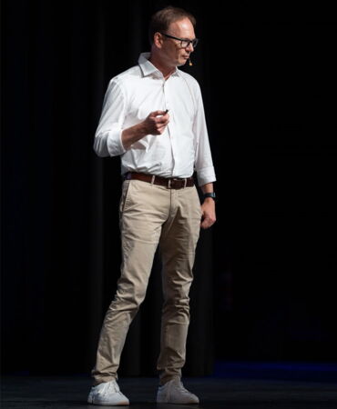 SSZ Beratung Keynotes und Vorträge Guido Zander hält Vortrag auf einer Bühne über das Thema "Arbeitszeit im Spannungsfeld von Krisen".